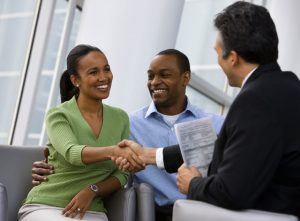 African American couple shaking hands with financial advisor