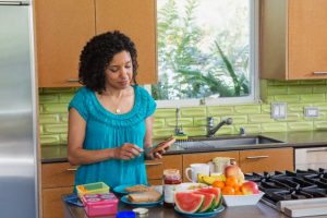 Mid-adult woman standing in kitchen preparing breakfast